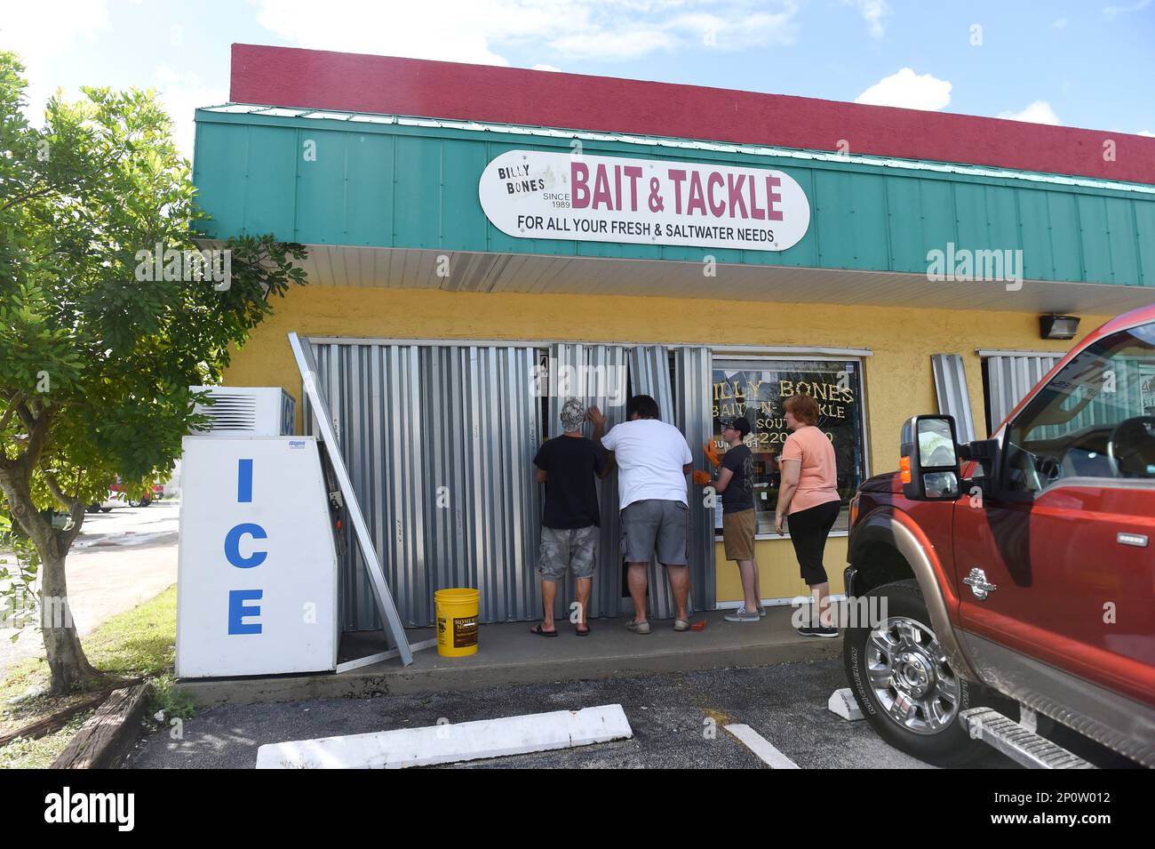 The Hrobak family, of Port St. Lucie, Fla.,install storm shutters ahead of  Hurricane Matthew on Wednesday, Oct. 5, 2016, at Billy Bones Bait-N-Tackle  South in Stuart. We're veterans at this, said Bruce