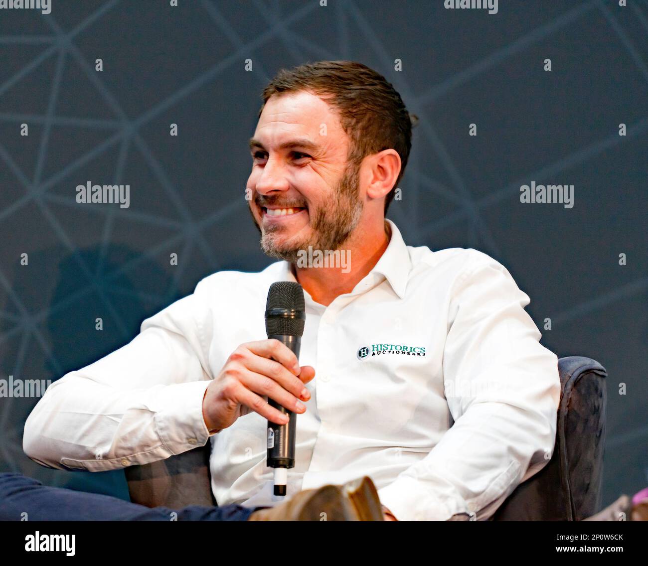 Close-up of Mathew Priddy, Car Specialist and Head of Auctions at Historics Auctioneers, discussing  60 years of the Porsche 911, on the main stage, at the 2023 London Classic Car Show Stock Photo