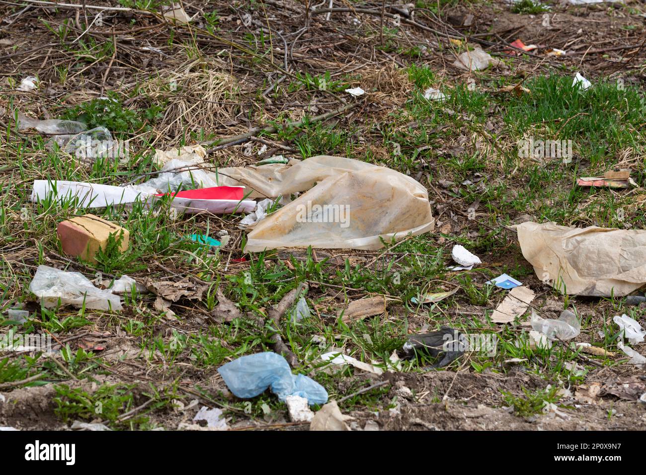 Spring forest stream river garbage waste plastic tire glass bottles after the snow melted
