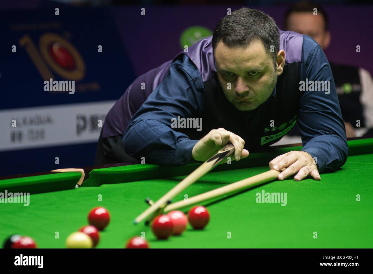 Stephen Maguire of Scotland plays a shot against Shaun Murphy of