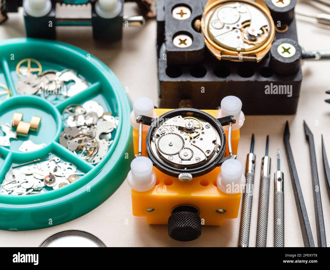 open watches in holders and tools on wooden table in watchmaker workshop Stock Photo