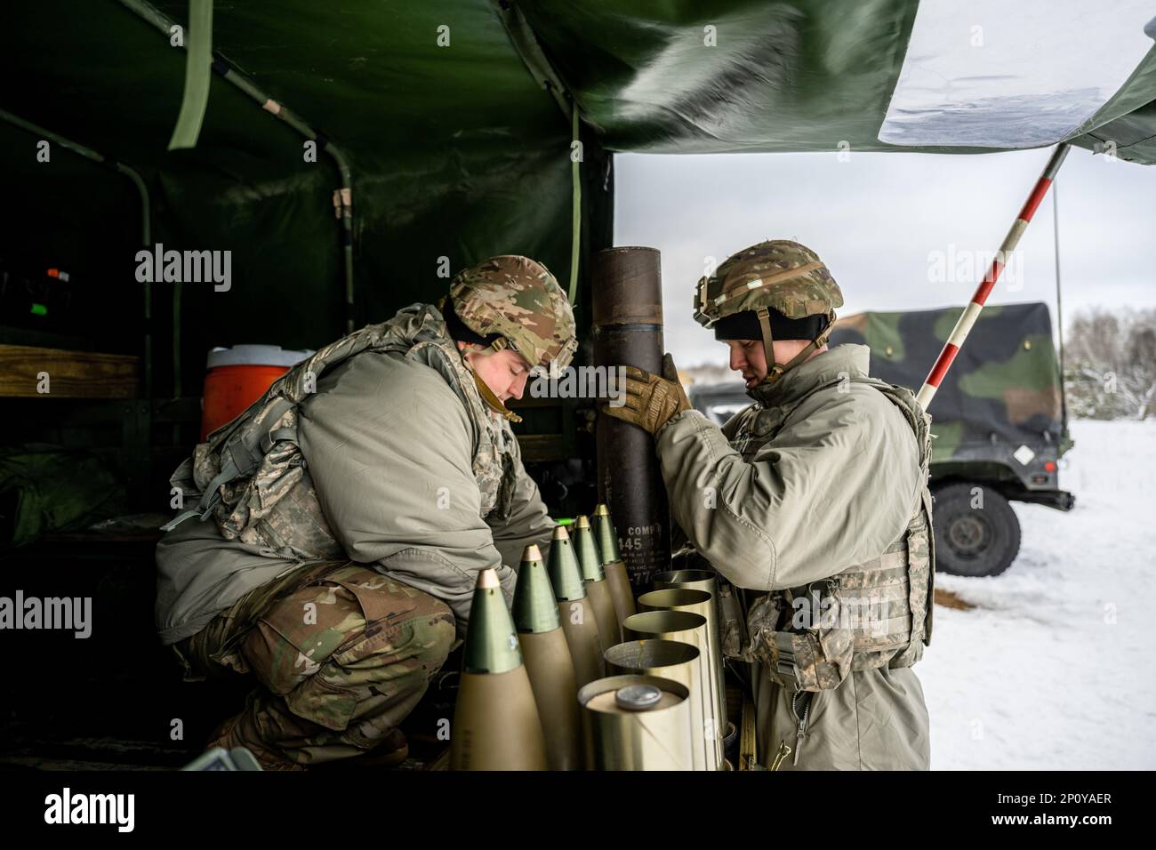 Army Cpl. Brady Kielpikowski and Pfc. Dominic Tilton, 1-120th Field Artillery Regiment, assemble a 105mm High Explosive shell to be used with the M119 howitzer during Northern Strike 23-1, Jan. 23, 2023, at Camp Grayling, Mich. Units that participate in Northern Strike’s winter iteration build readiness by conducting joint, cold-weather training designed to meet objectives of the Department of Defense’s Arctic Strategy. Stock Photo