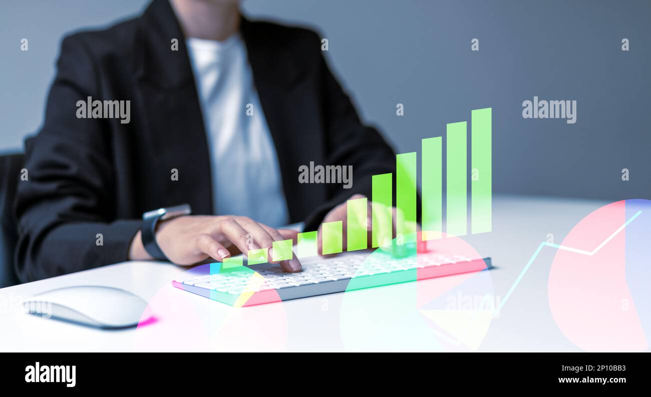 Female business person working on computer analyses business digital chart. Stock Photo