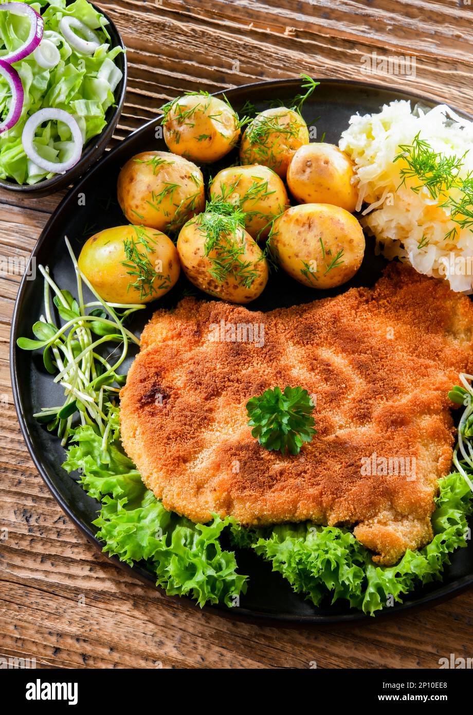 Pork breaded cutlet coated with breadcrumbs served with potatoes and