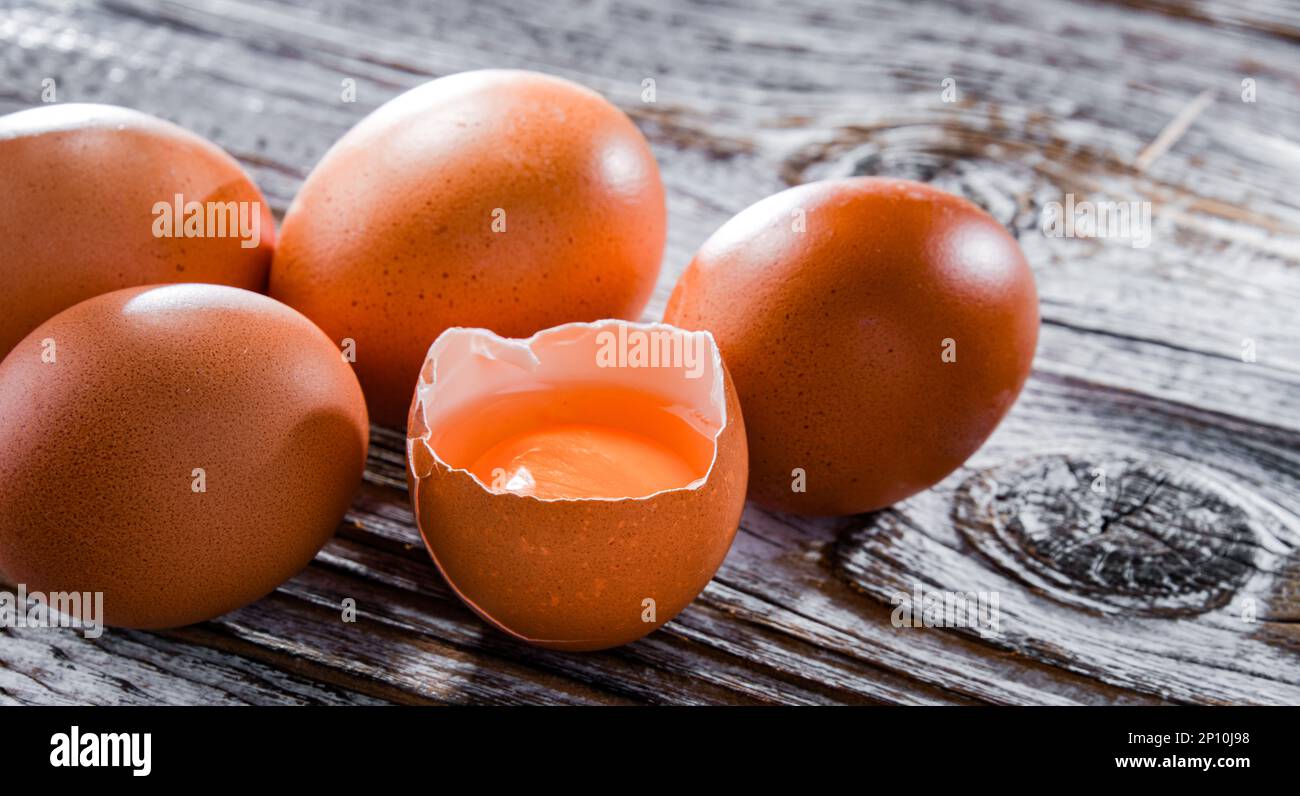 Composition with five chicken eggs on a wooden table. Stock Photo