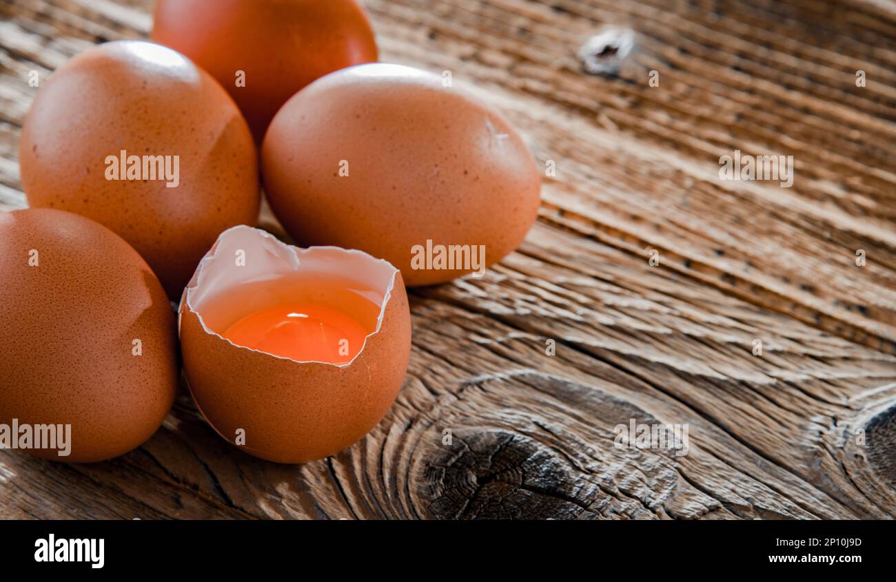 Composition with five chicken eggs on a wooden table. Stock Photo
