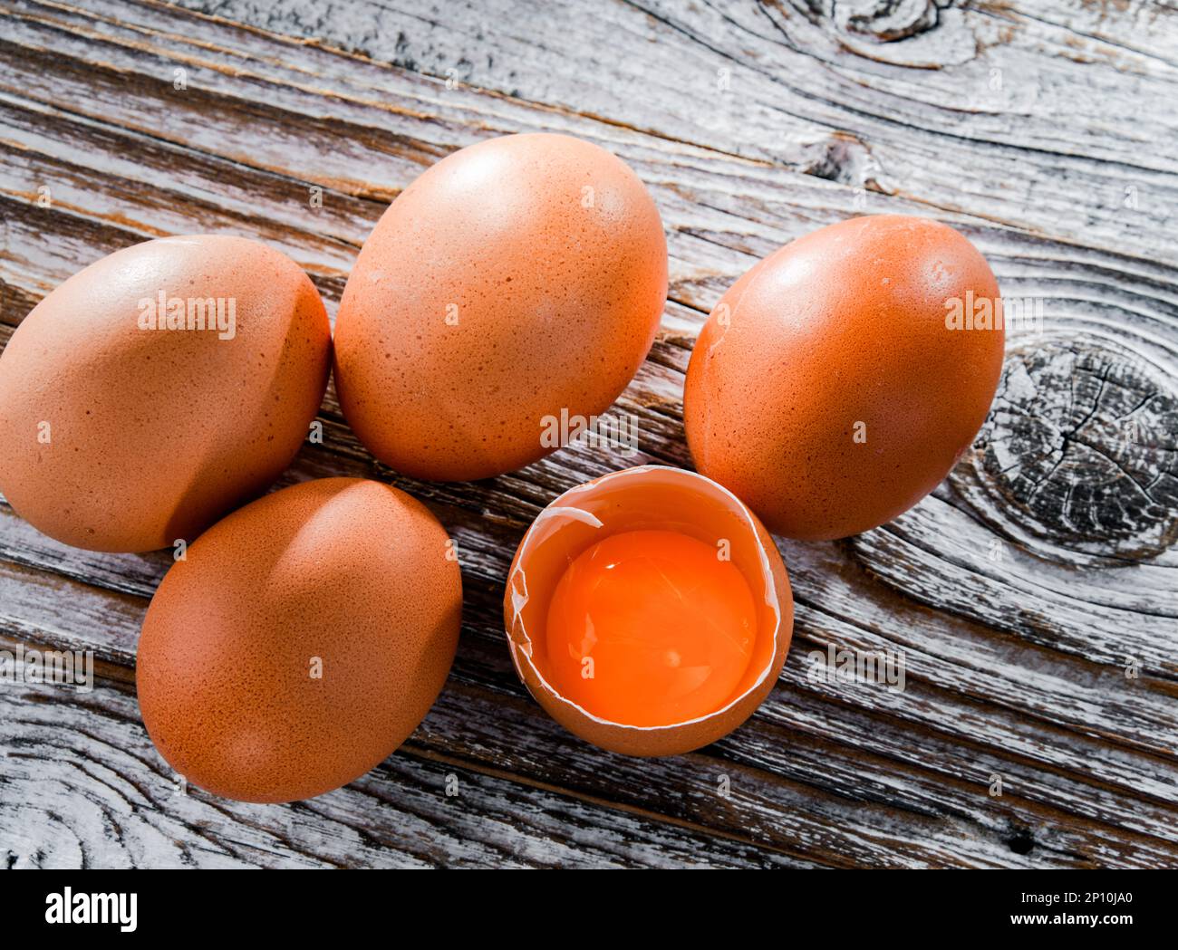 Composition with five chicken eggs on a wooden table. Stock Photo