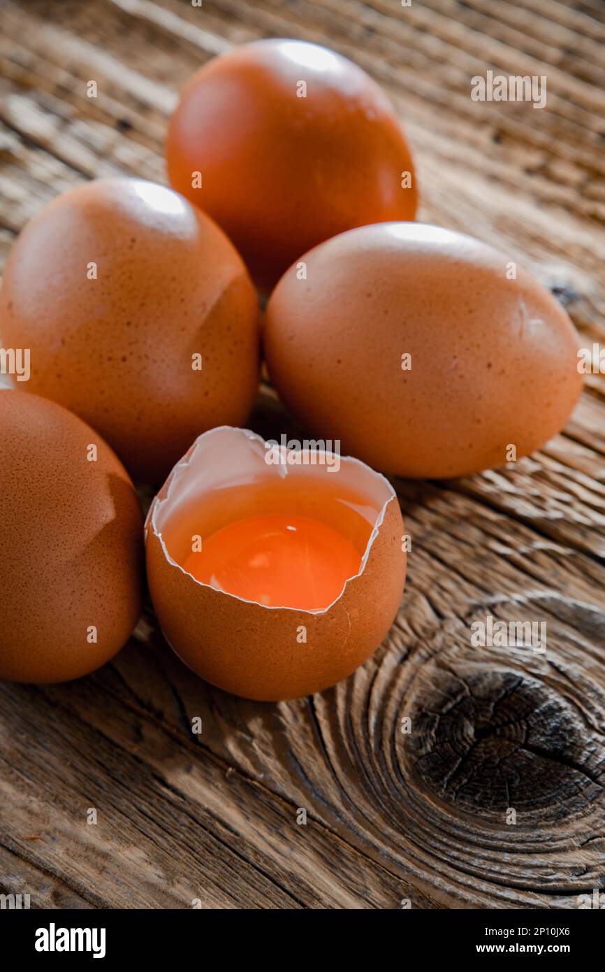 Composition with five chicken eggs on a wooden table. Stock Photo