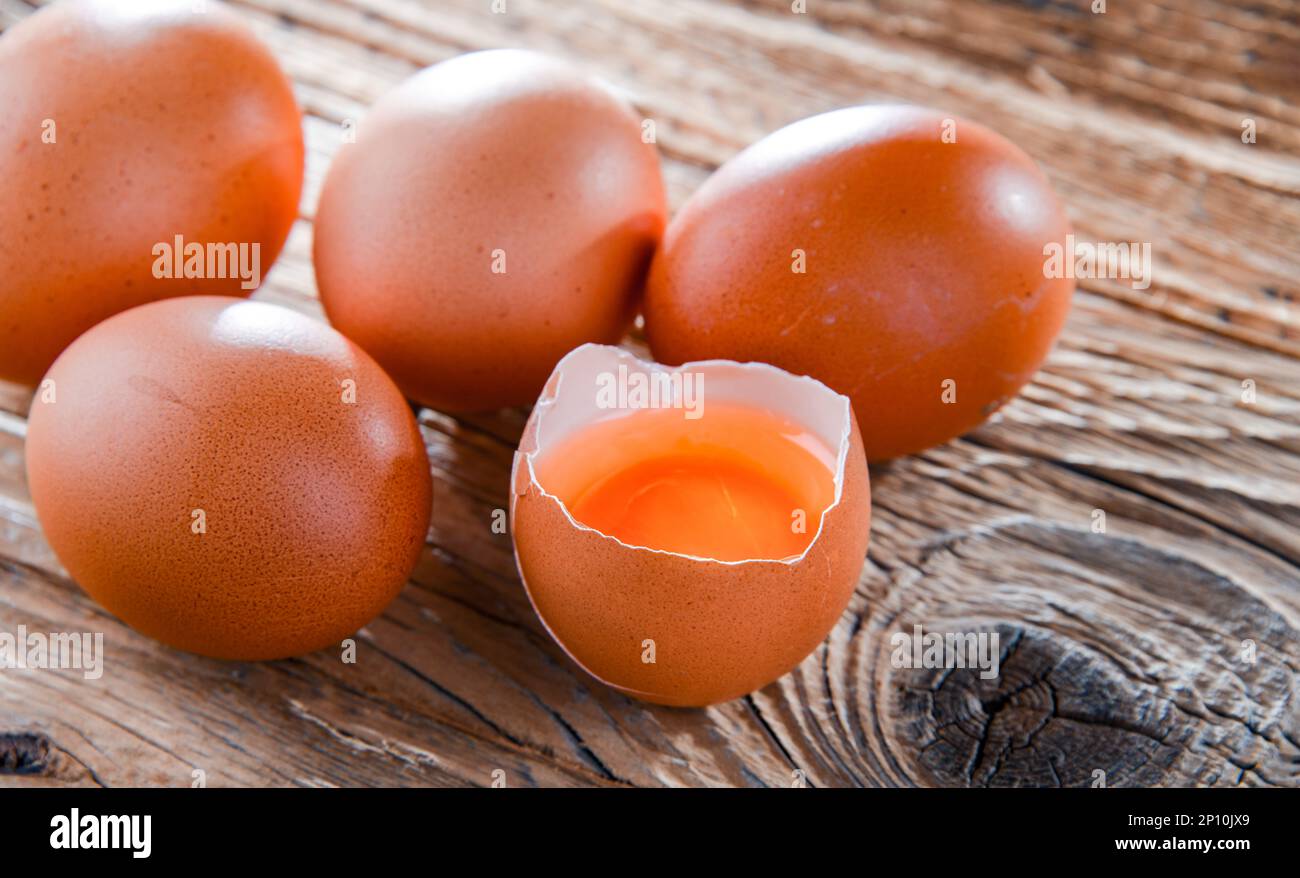 Composition with five chicken eggs on a wooden table. Stock Photo