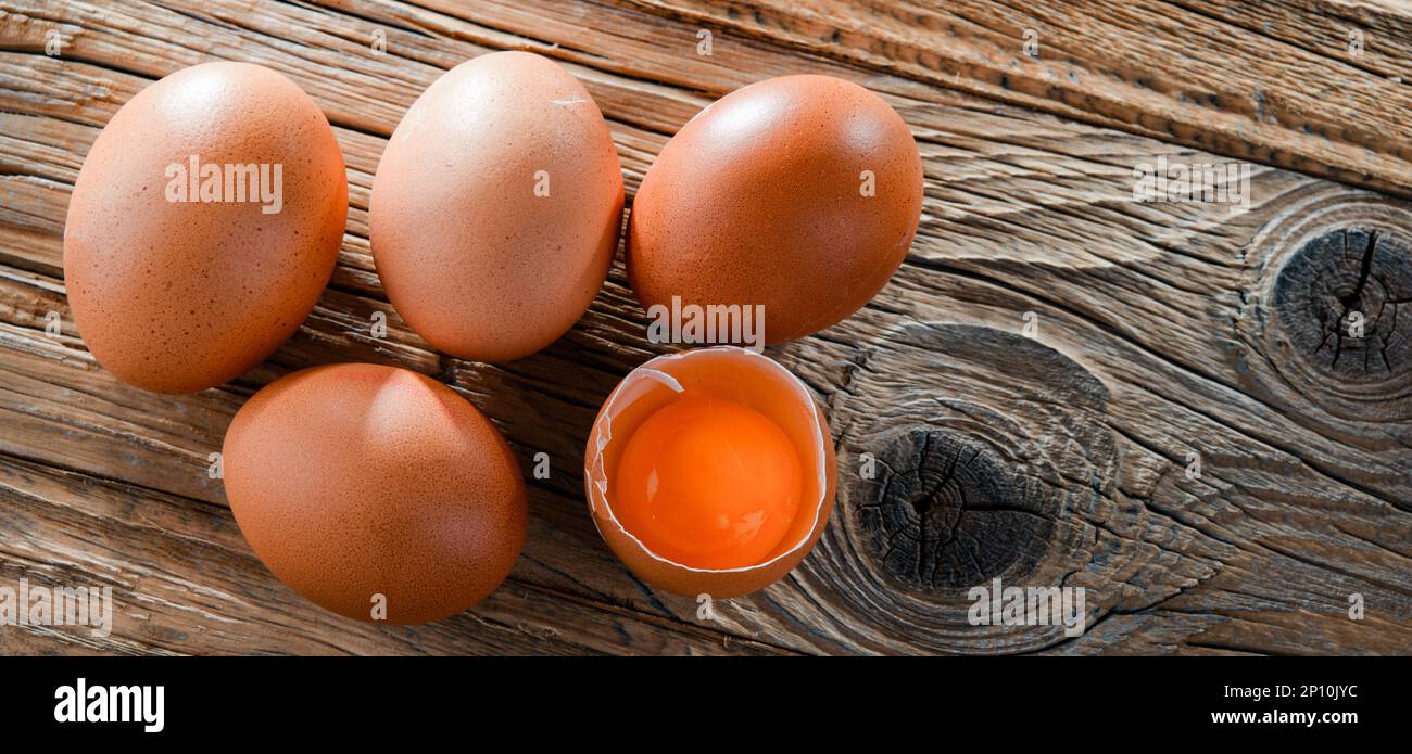 Composition with five chicken eggs on a wooden table. Stock Photo