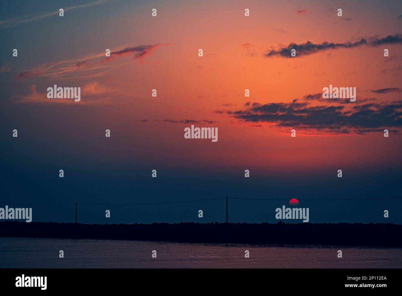 A tranquil scene of a breathtaking sunset reflecting on the calm body ...
