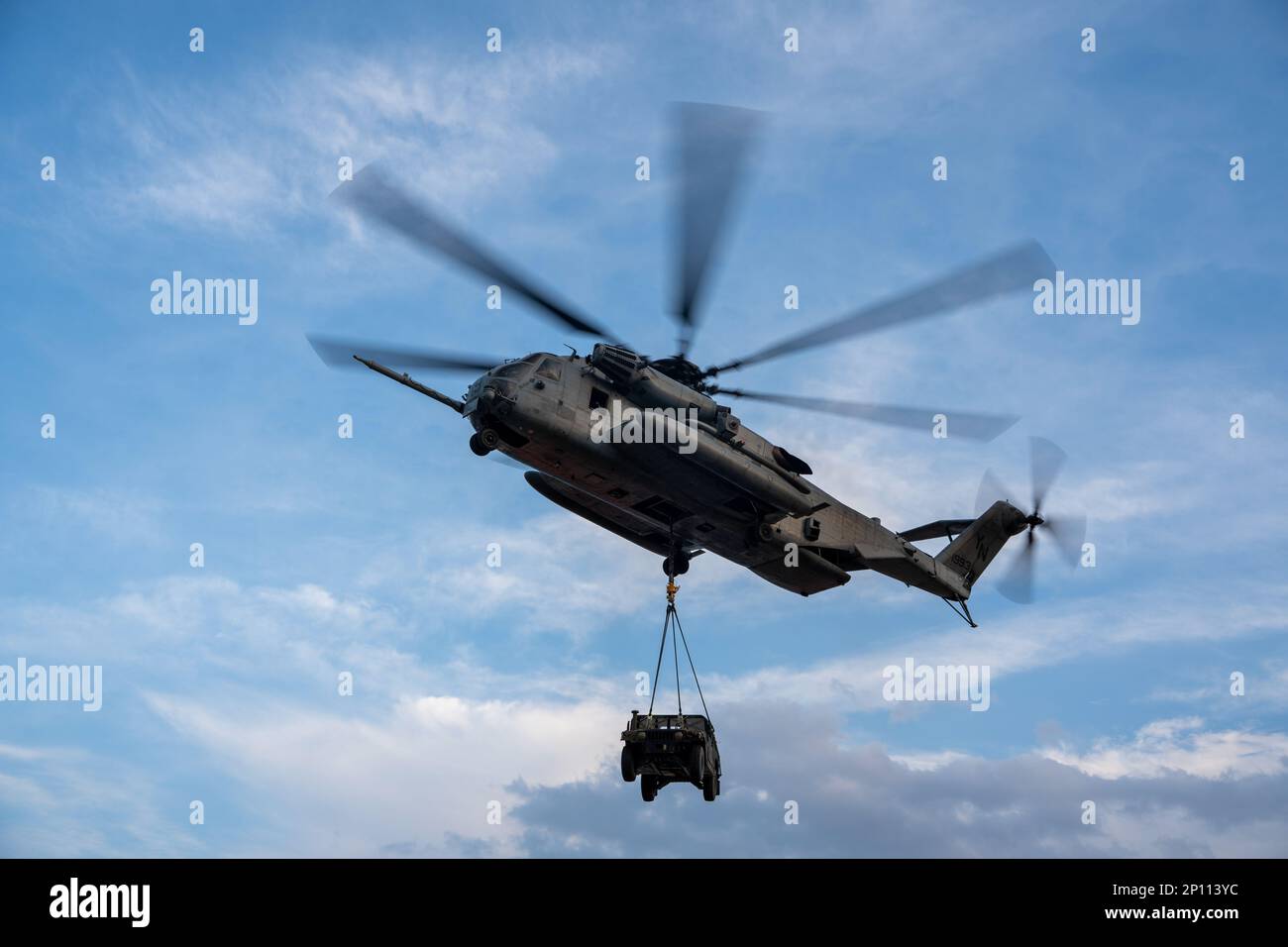 A U.S. Marine Corps CH-53E Super Stallion helicopter with Marine Medium Tiltrotor Squadron 262 (Reinforced), 31st Marine Expeditionary Unit (MEU), hoists a Humvee during external lift training at Marine Corps Air Station Iwakuni, Japan, Feb. 19, 2023. This helicopter support team exercise was conducted to certify pilots in sling load operations and improve tactical proficiency. The 31st MEU, the Marine Corps’ only continuously forward-deployed MEU, provides a flexible and lethal force ready to perform a wide range of military operations as the premiere crisis response force in the Indo-Pacific Stock Photo