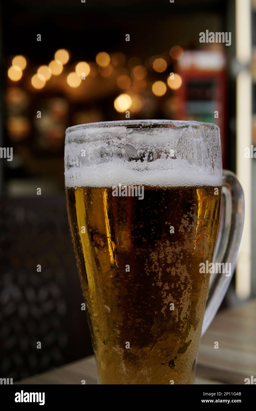 cold beer mug outdoors with background lights Stock Photo