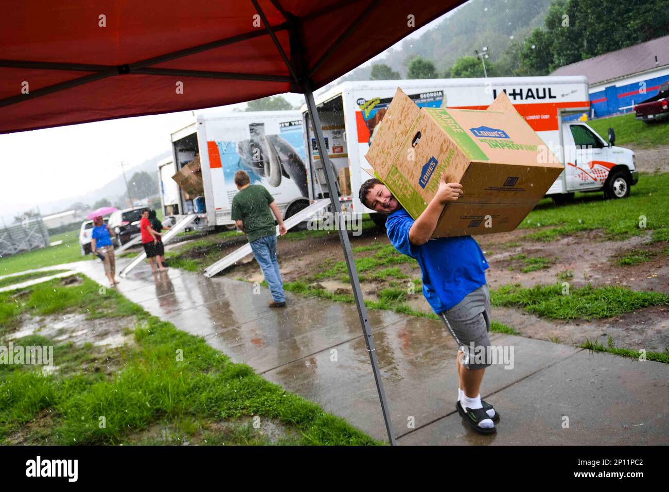 Elkview Middle School Student Jacob Dennis, right, moves a box of shoes indoors as a passing