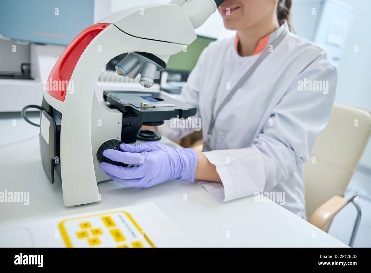 examines under microscope sample of biomaterial for DNA test