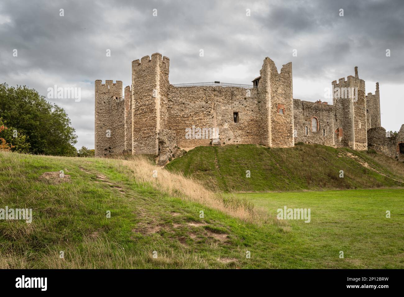 Beautiful English castle seen surrounded by lush grass mounds in the English countryside. Stock Photo