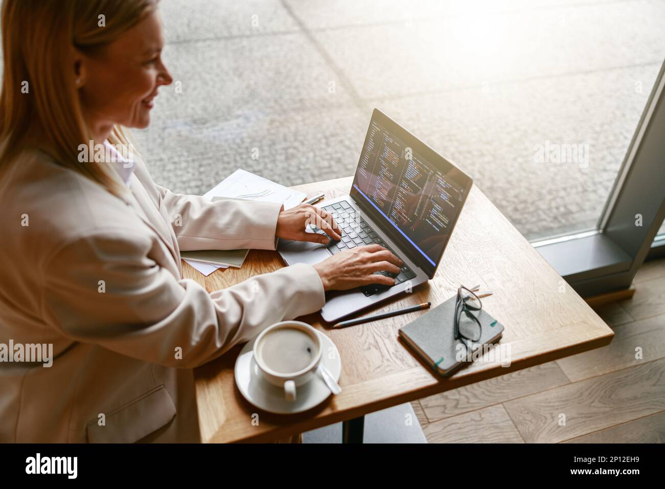 Woman freelance programer working on laptop while sitting in cafe. Data done right Stock Photo