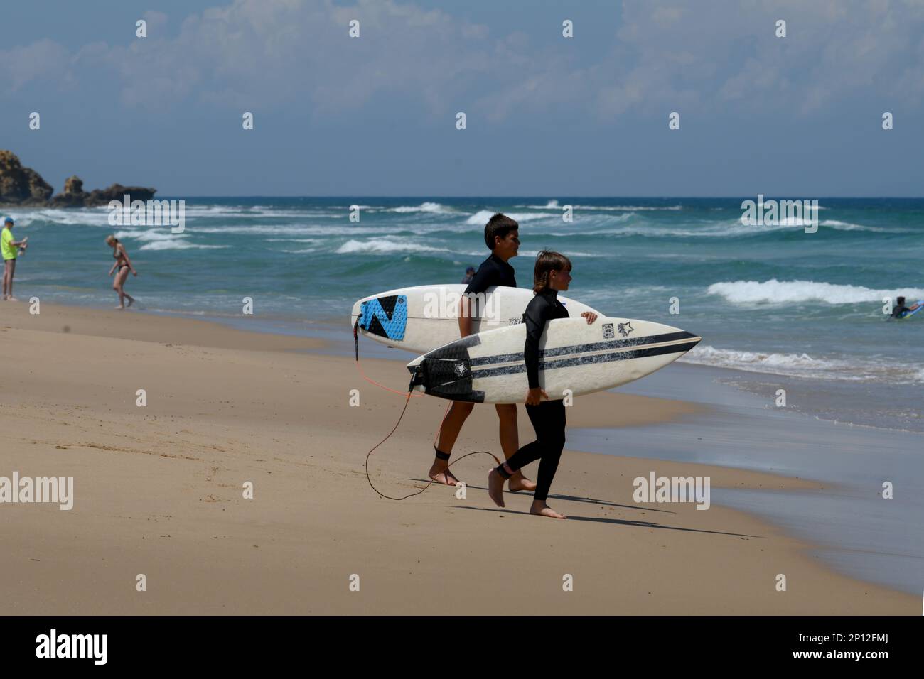 2 surfers with surfboards  check the surf on the beach at Jan Juc near Torquay, Victoria, Australia Stock Photo