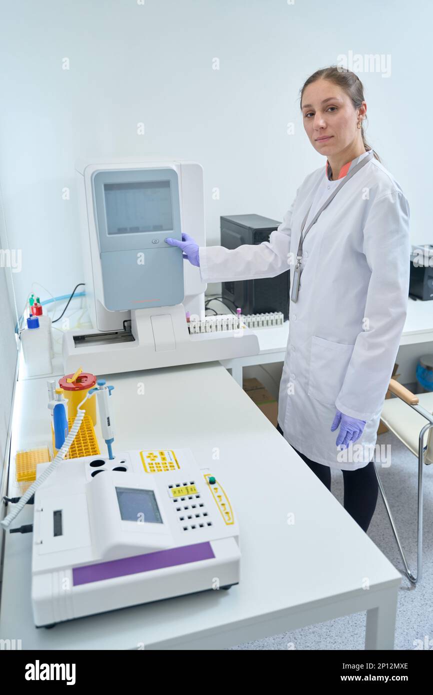 Hemometer Assistant Health worker turns on the hematology analyzer Stock Photo - Alamy
