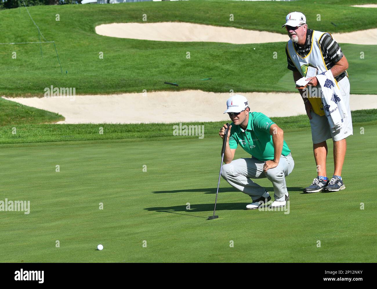 14 AUG 2016 Golfer Zach Johnson and his caddie line up a putt on the