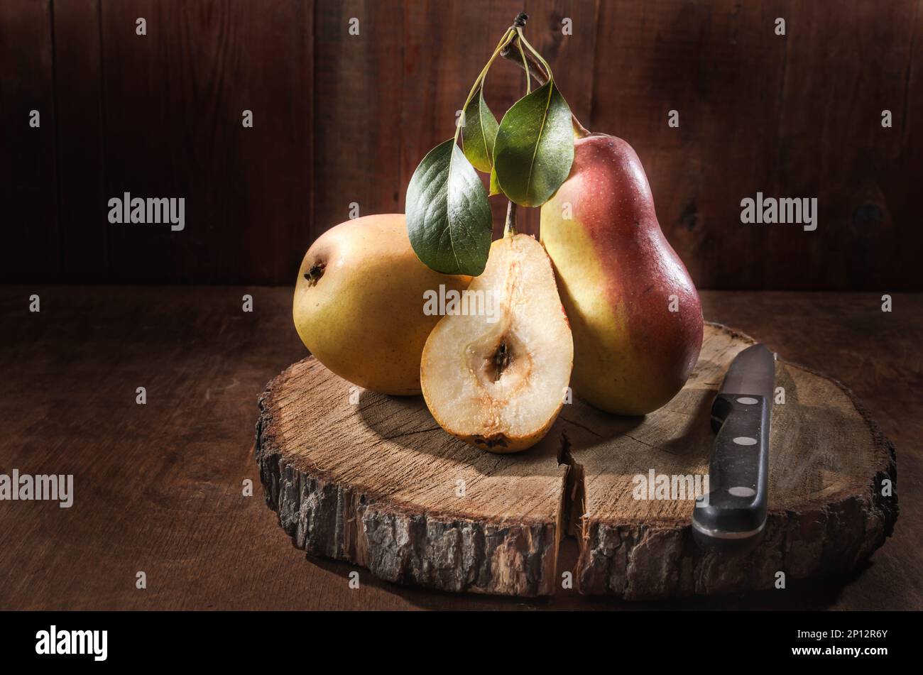 Ripe pear and a bunch of viburnum berries on a dark wooden background ...