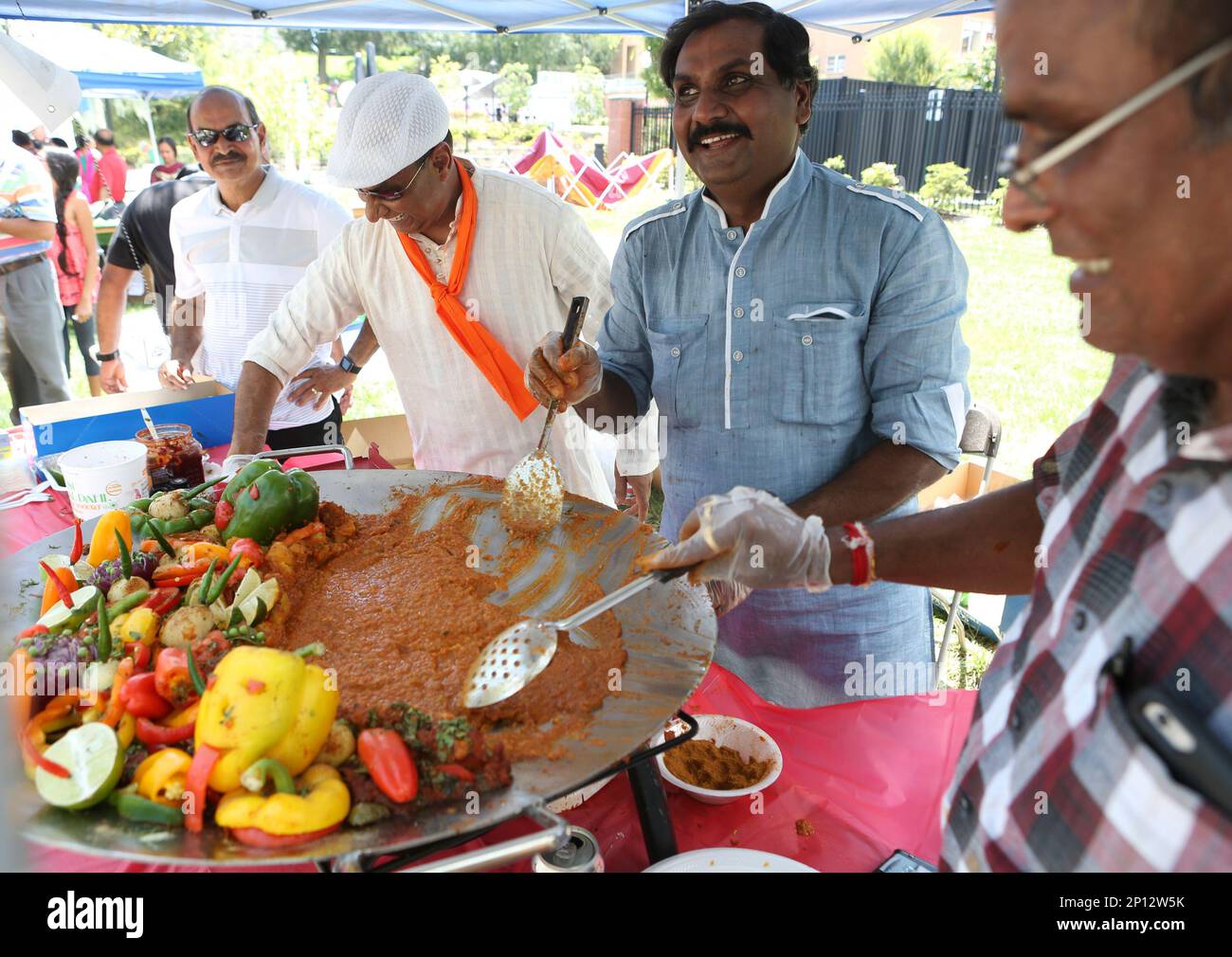 Family members and friends prepare a vegetarian dish called pav bhaji