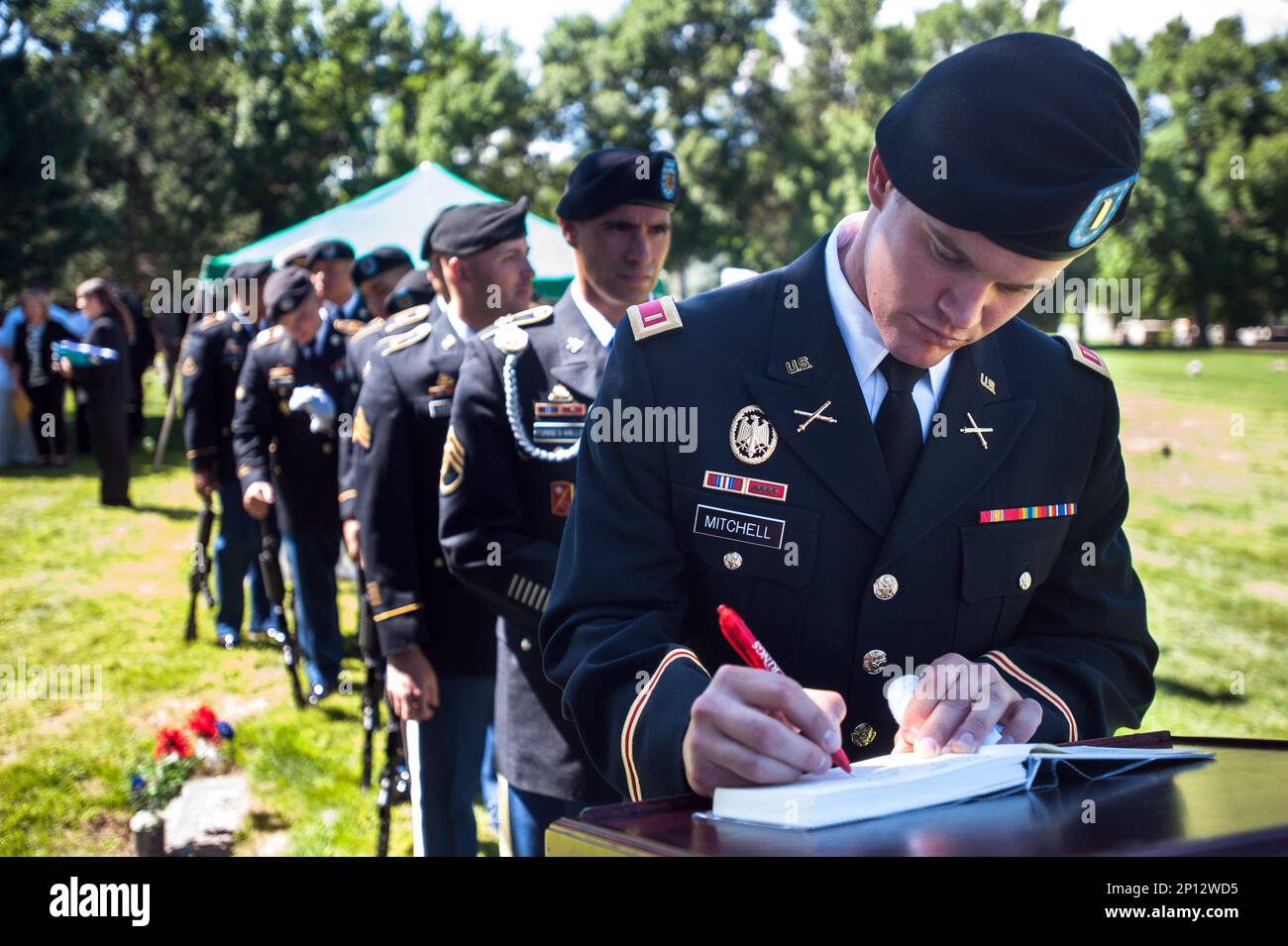 Second lieutenant Thomas Mitchell of the Fort Carson Military Funeral Honors Team signs the