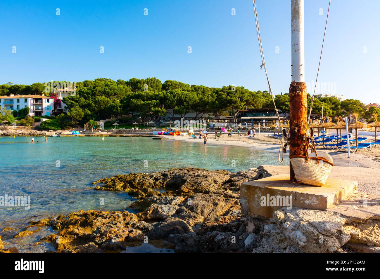Cala Xinxell cove, Ses Illetes, Majorca, Balearic Islands, Spain. July 20th, 2022 - The cove with some apartments in a pinewood next to the rocky coas Stock Photo
