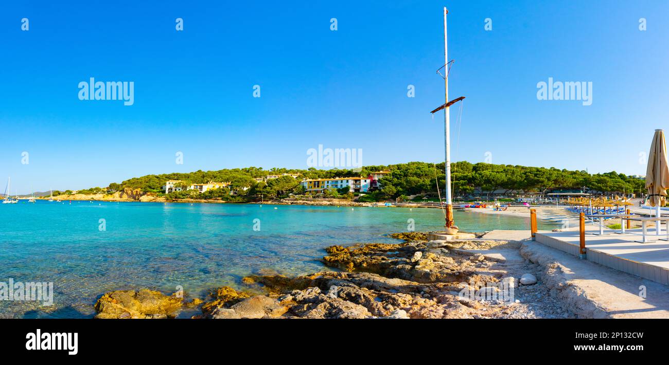 Cala Xinxell cove, Ses Illetes, Majorca, Balearic Islands, Spain. July 20th, 2022 - Panorama of the cove with some apartments and a bar terrace next t Stock Photo