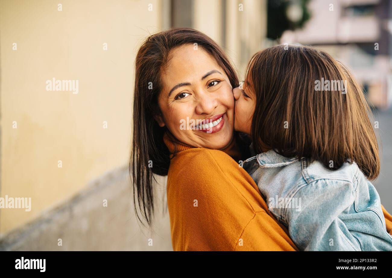 Happy filipina mother with her daughter having tender moments in the city center - Lovely family outdoor Stock Photo