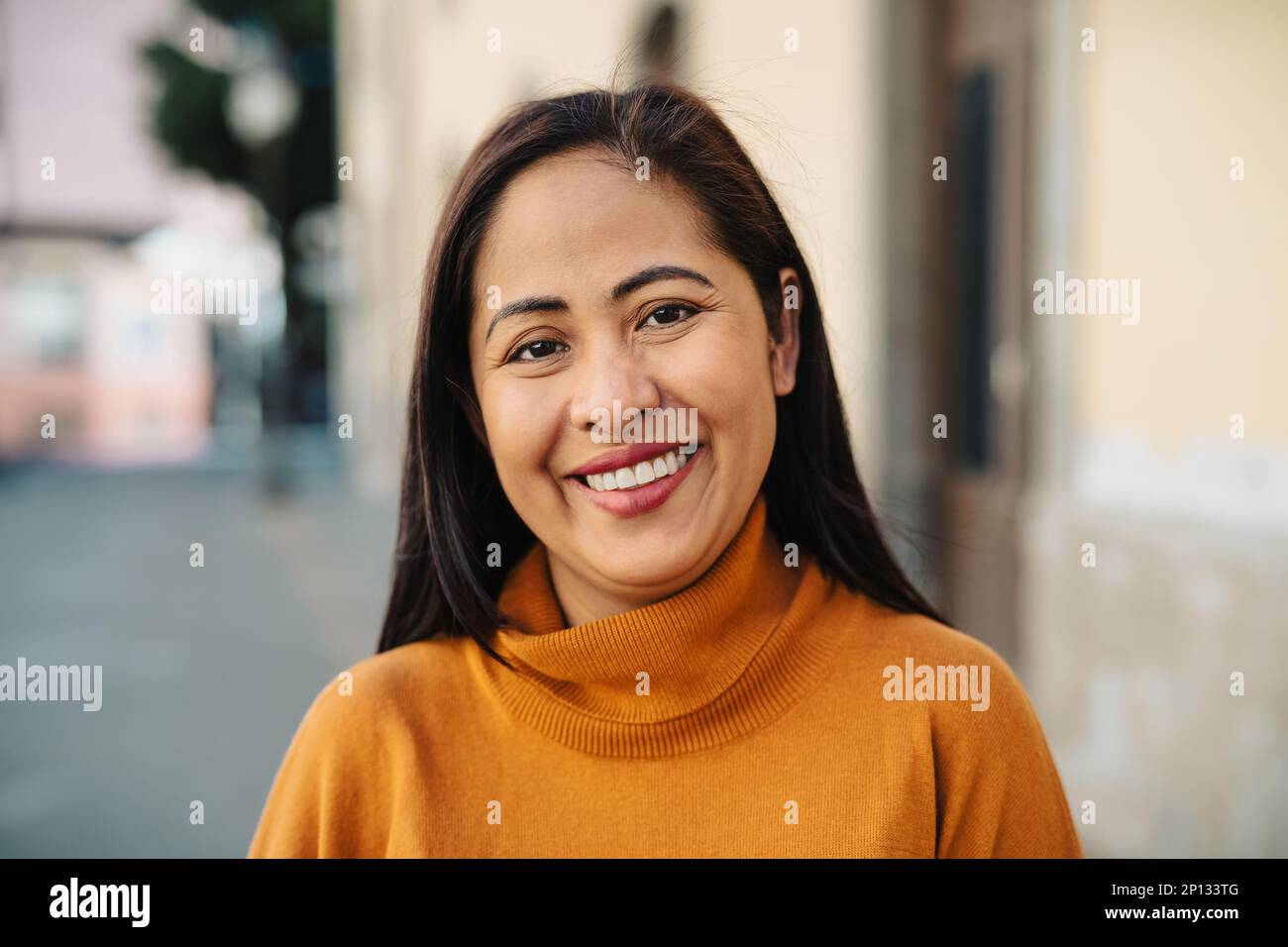 Happy filipina woman having fun smiling in front of camera in the city center Stock Photo