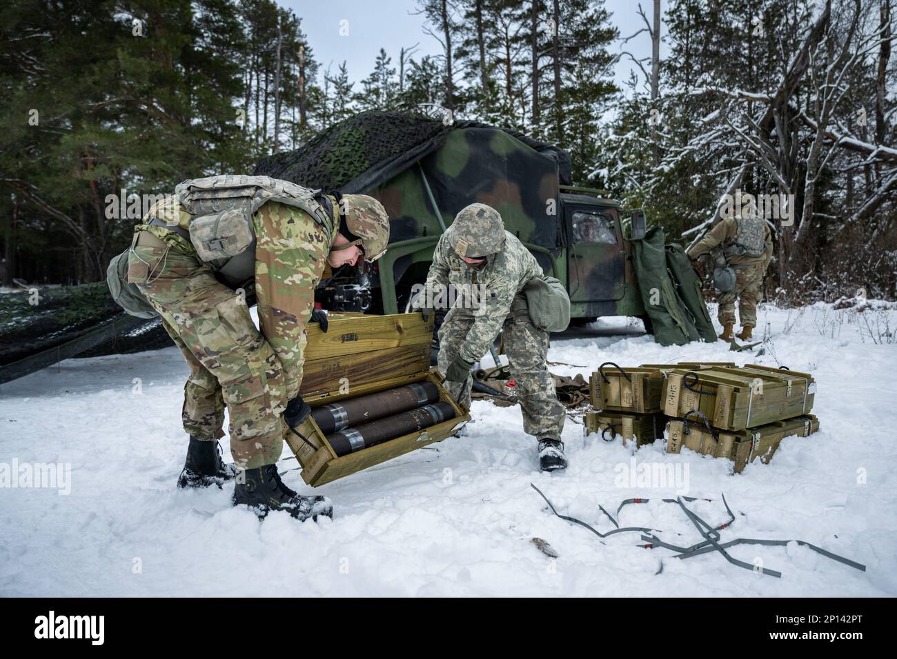 Army Sgt. Meranda Leisgana and Sgt. Trayton Pankratz, 1-120th Field Artillery Regiment, opens a wooden crate of 105mm High Explosive shells for the M119 howitzer during Northern Strike 23-1, Jan. 25, 2023, at Camp Grayling, Mich. Units that participate in Northern Strike’s winter iteration build readiness by conducting joint, cold-weather training designed to meet objectives of the Department of Defense’s Arctic Strategy. Stock Photo