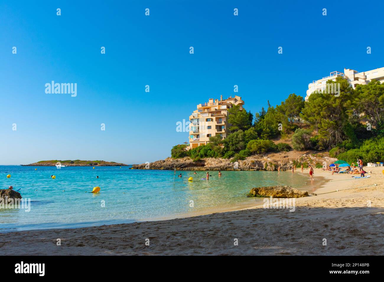 Ses Illetes, Majorca, Balearic islands, Spain. July 20th, 2022 - Apartments in a pinewood next to the beach and the Caleta island Stock Photo