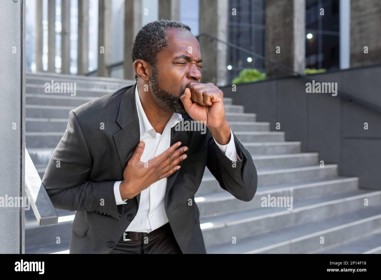 Cough attack on the street. Senior African American businessman