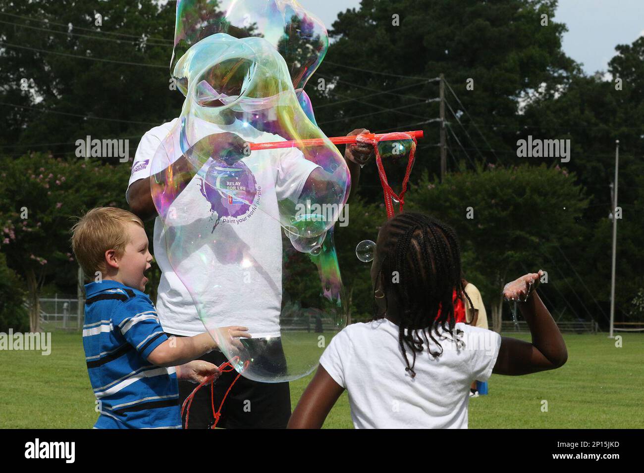 Children play with huge bubbles as family and friends enjoy themselves