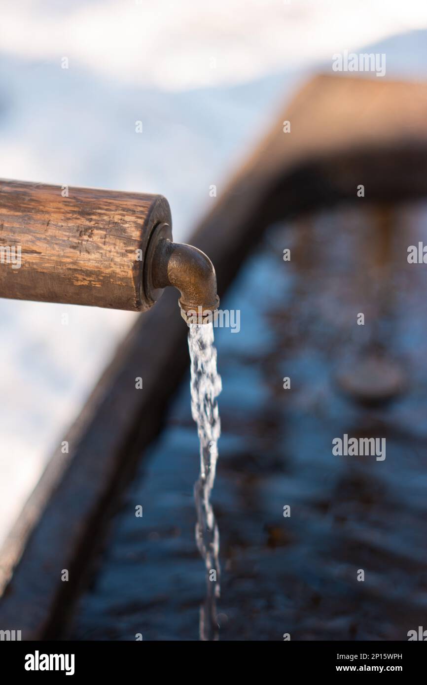 Clean running drinking water from a forest fountain tap in the winter