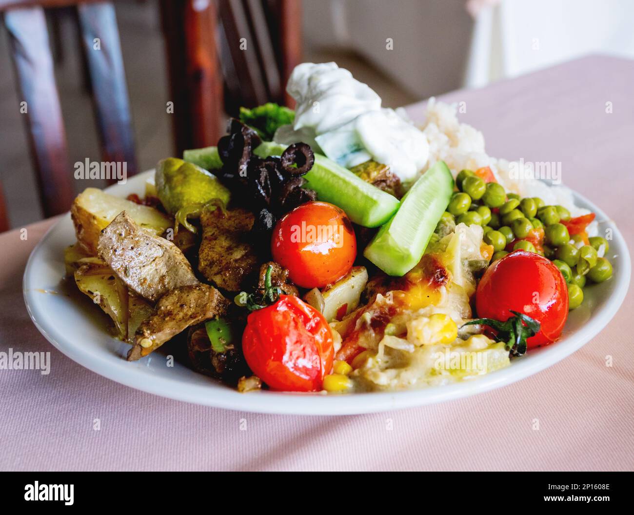 Healthy dinner - plate full of stewed vegetables, rice and meat with natural yogurt. Stock Photo
