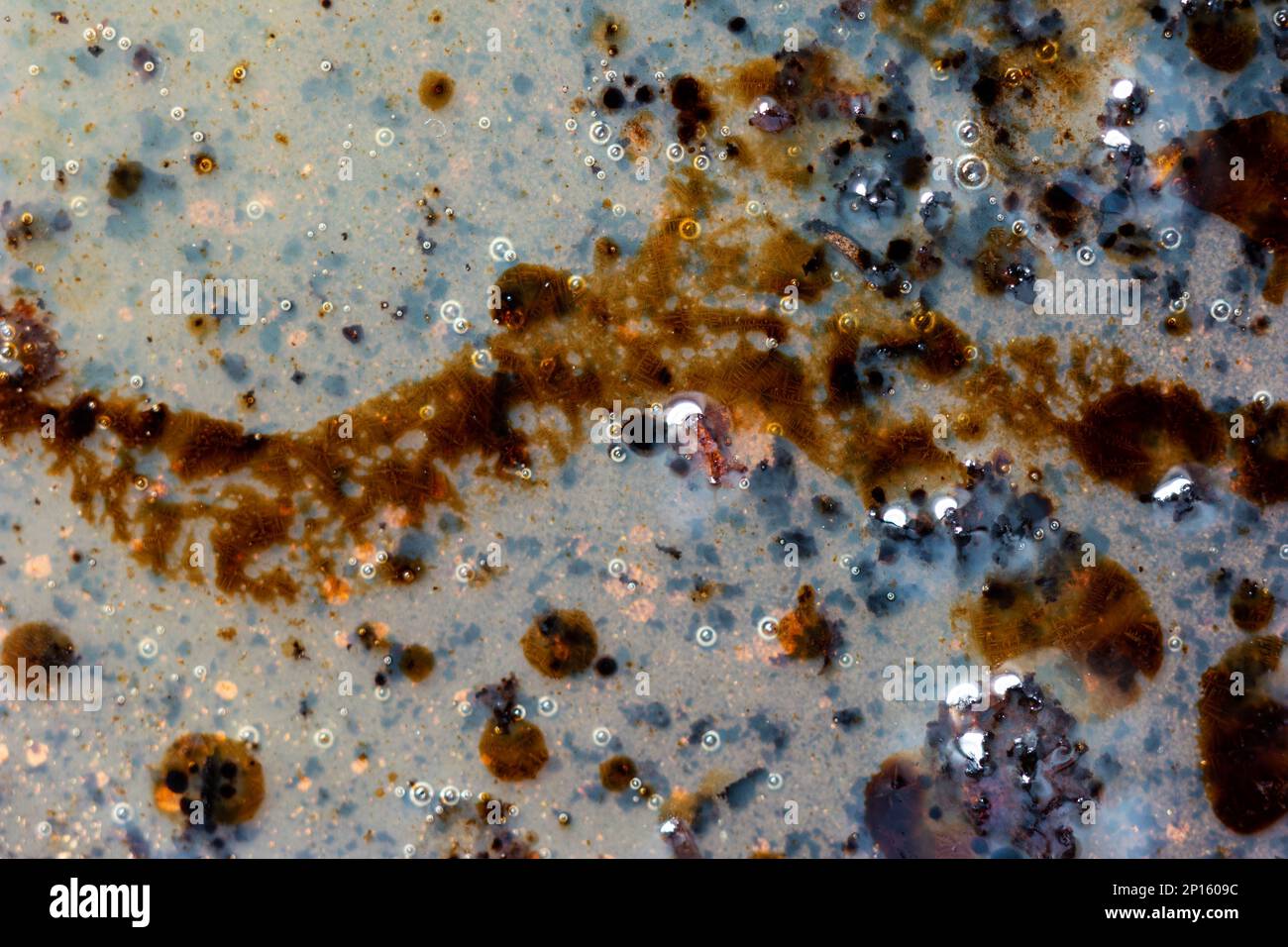 Burned oily leftover grease fat in a pan macro shot air bubbles top