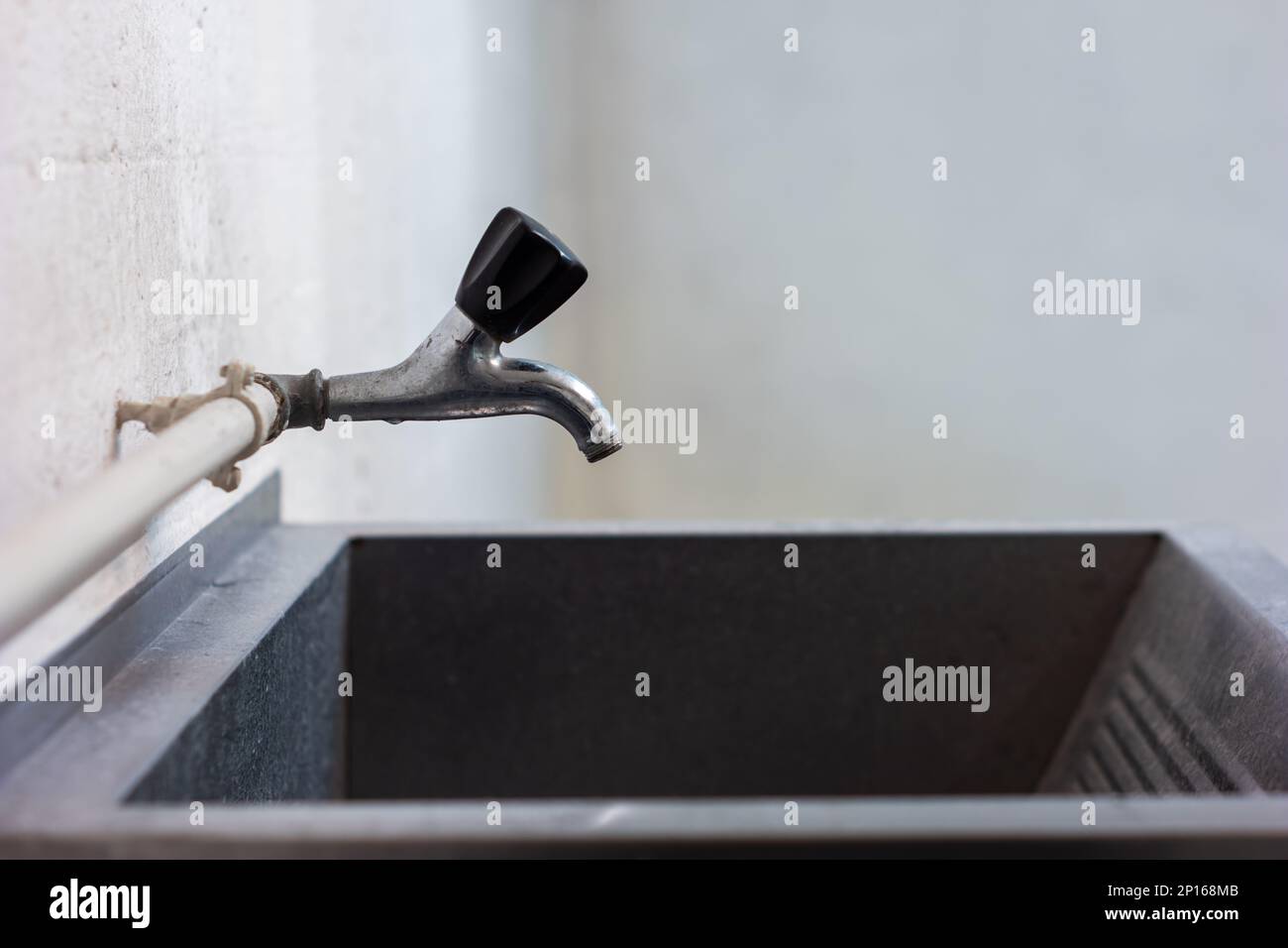 Old tap water faucet and large sink wall mounted inside common use