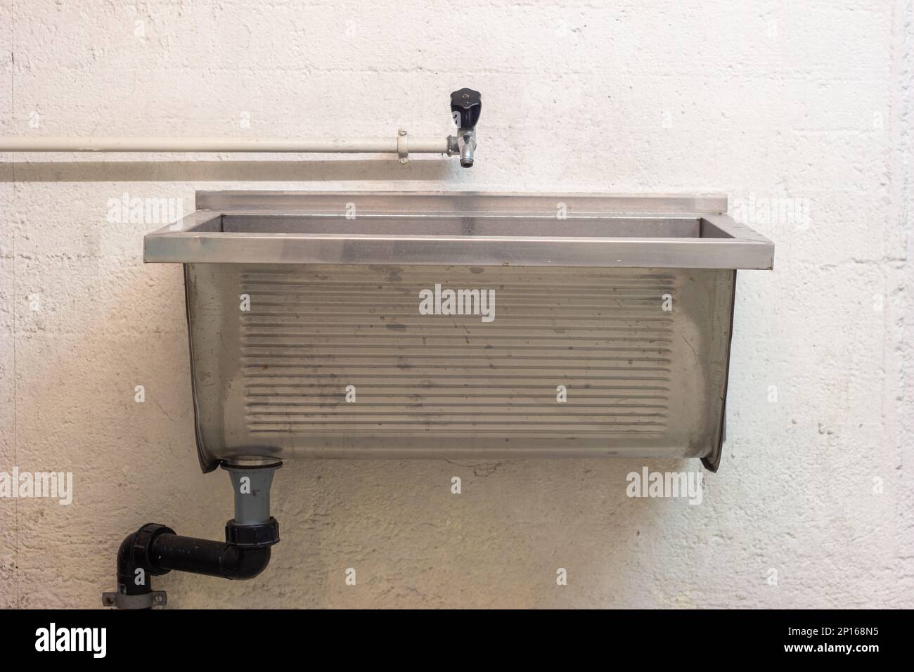 Old tap water faucet and large sink wall mounted inside common use