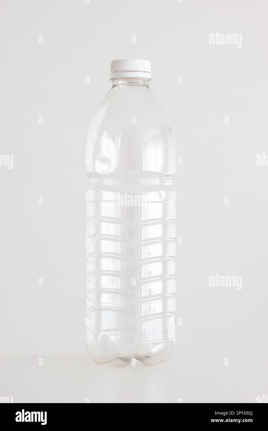 Clear empty plastic bottle with red lid isolated on white vertical shot. Stock Photo