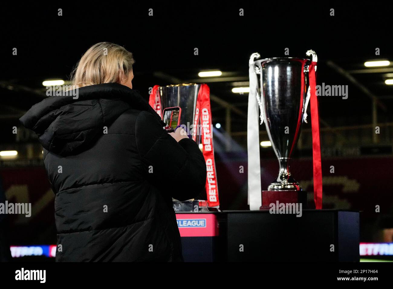 Sky Sports presenter Jenna Brooks takes a photo of the The Betfred Super League trophy and the World Club Champions Trophy before the Betfred Super League Round 3 match St Helens vs Leeds Rhinos at Totally Wicked Stadium, St Helens, United Kingdom, 3rd March 2023  (Photo by Steve Flynn/News Images) Stock Photo