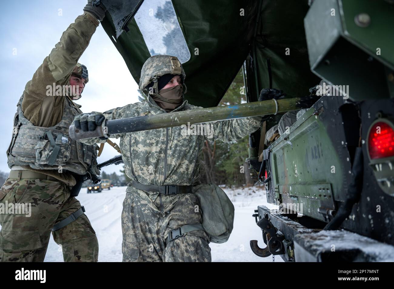 Army Sgt. Meranda Leisgana gets help from Pfc. Cameron Patzner, both from 1-120th Field Artillery Regiment, as she pulls out a crossbar for the M119 howitzer during Northern Strike 23-1, Jan. 25, 2023, at Camp Grayling, Mich. Units that participate in Northern Strike’s winter iteration build readiness by conducting joint, cold-weather training designed to meet objectives of the Department of Defense’s Arctic Strategy. Stock Photo