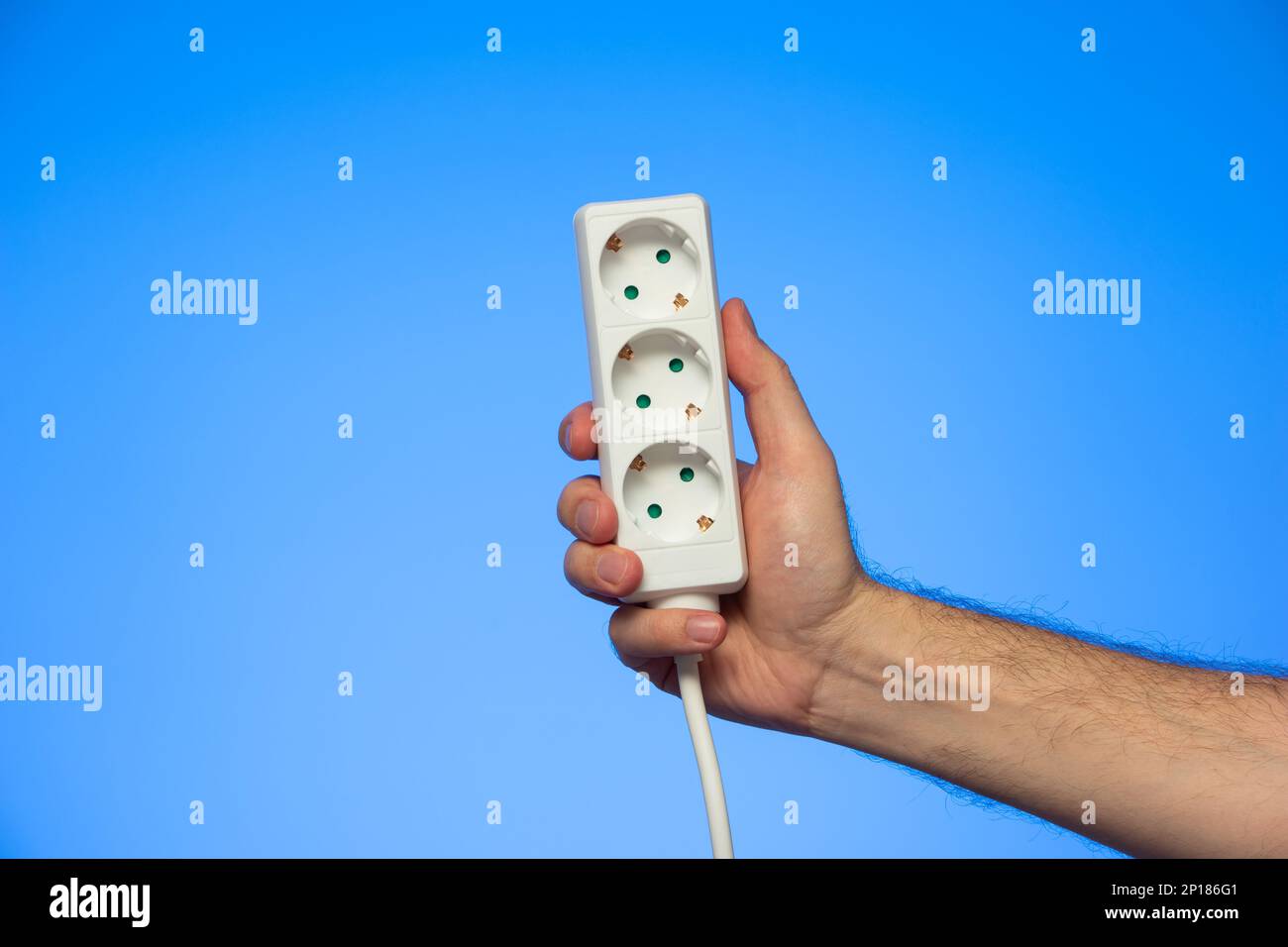 Electrical extension cord with multiple plug sockets held in hand by