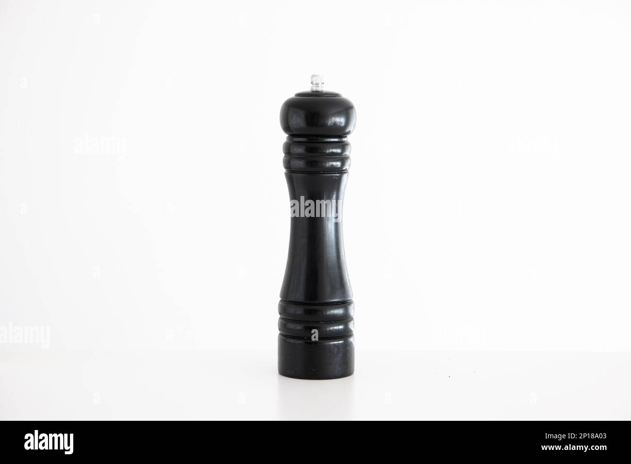 Wooden black pepper grinder mill studio shot isolated on white Stock
