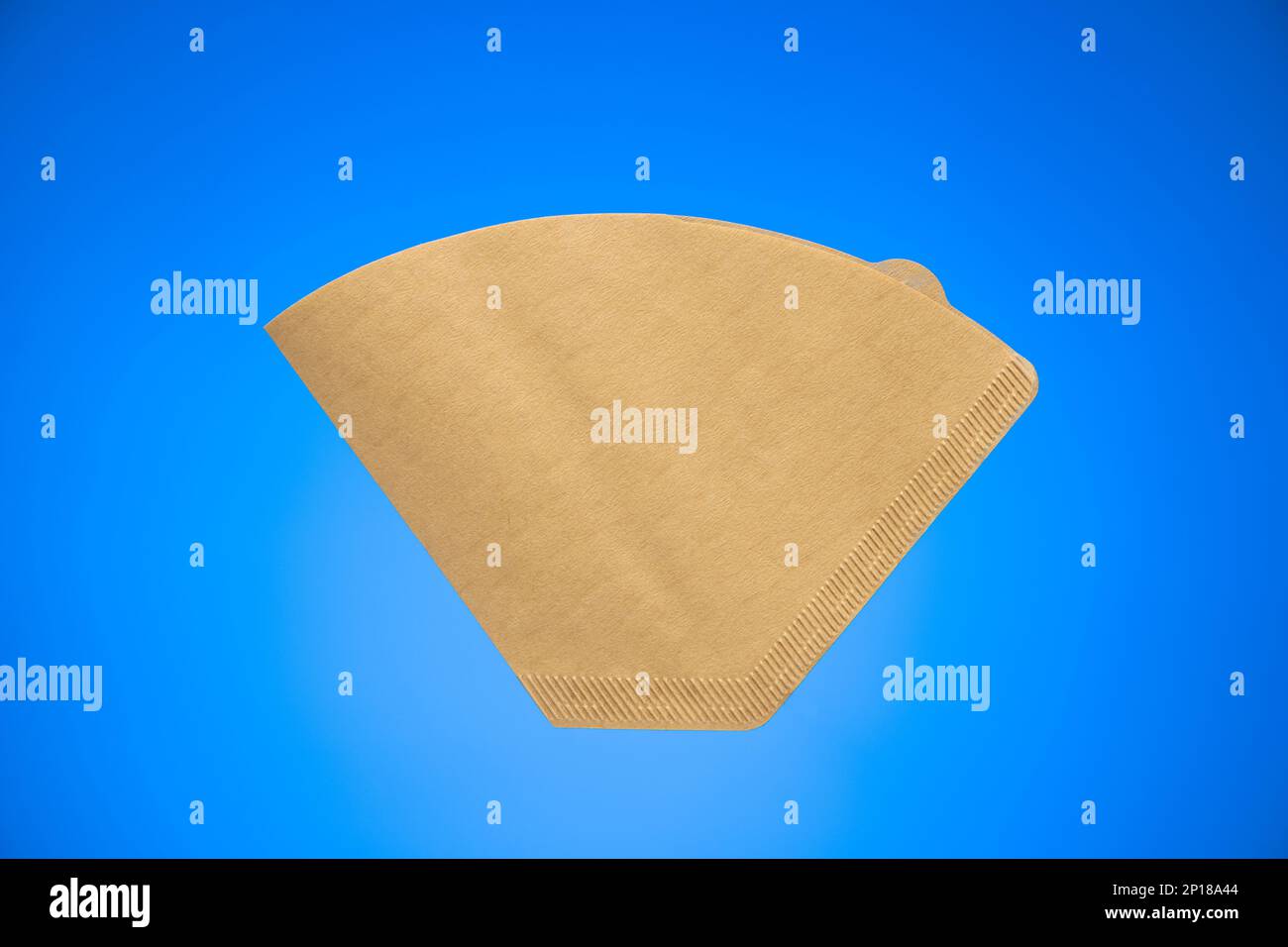 Single use brown paper coffee filter studio shot isolated on blue