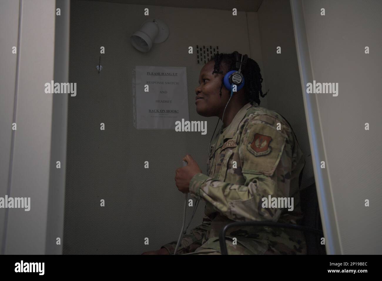U.S. Air Force Senior Airman Zelie Awoukeng Kenfak, 86th Operational Medical Readiness Squadron, public health epidemiology technician, receives a hearing exam at Ramstein Air Base, Germany, Jan. 27, 2023. Patients are screened for their ability to detect the loudness and pitch of varying tones. Stock Photo