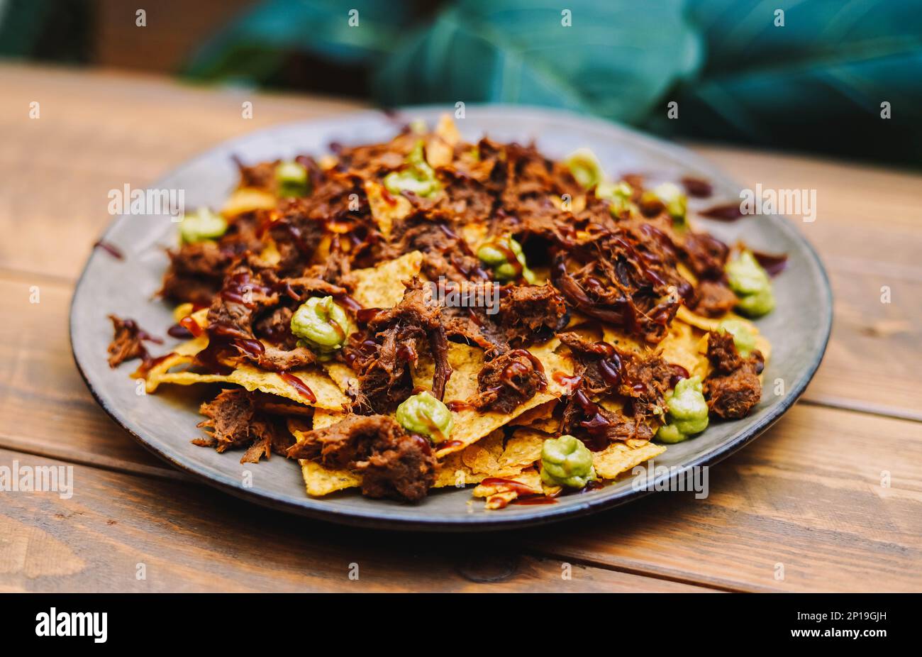 Mexican nachos with beef and chilli on wooden table Stock Photo