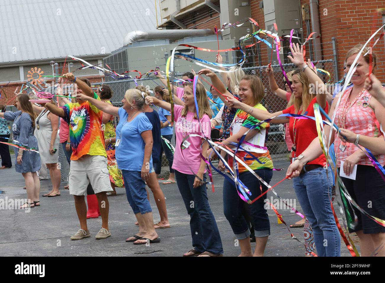 Teachers at White Oak Elementary School in Carteret, NC., wave goodbye to their students on the