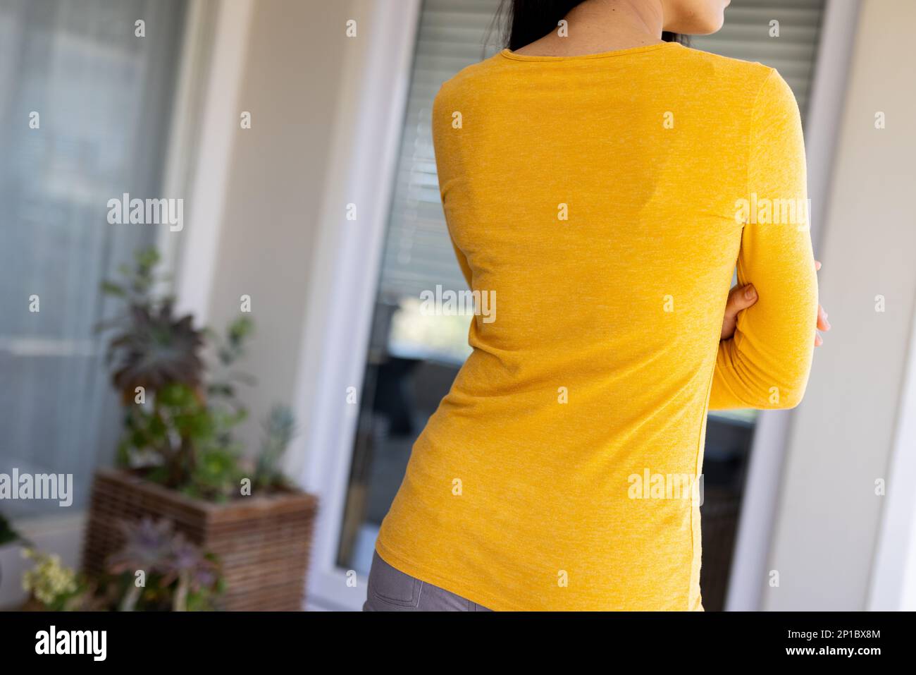 Midsection of biracial woman wearing yellow long-sleeve shirt with copy space Stock Photo